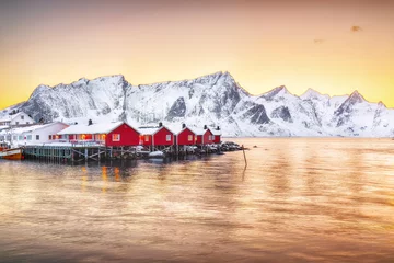 Papier Peint photo autocollant Reinefjorden Traditional Norwegian red wooden houses (rorbuer) on the shore of  Reinefjorden near Hamnoy village at sunset.