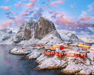 Amazing sunset winter view on Hamnoy village and Festhaeltinden mountain on background.