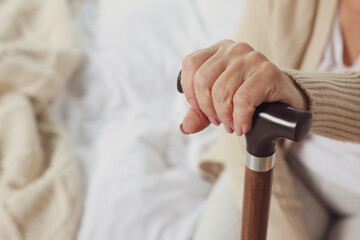Elderly woman with walking cane indoors, closeup. Home care service