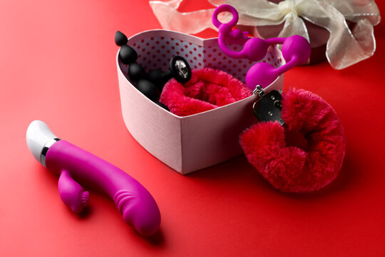 Gift Box With Different Sex Toys On Red Background