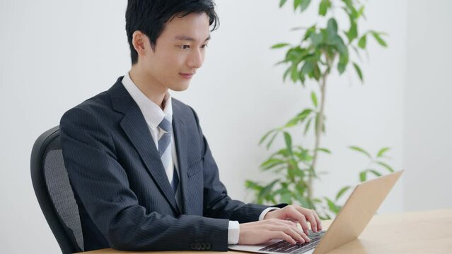 パソコンを使って仕事する若いビジネスマン	
