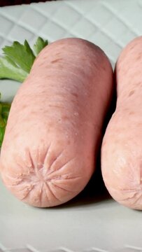 Two boiled sausage with fresh parsley and mustard.