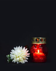 Candle and white chrysanthemum on dark background with copy space. Sympathy card