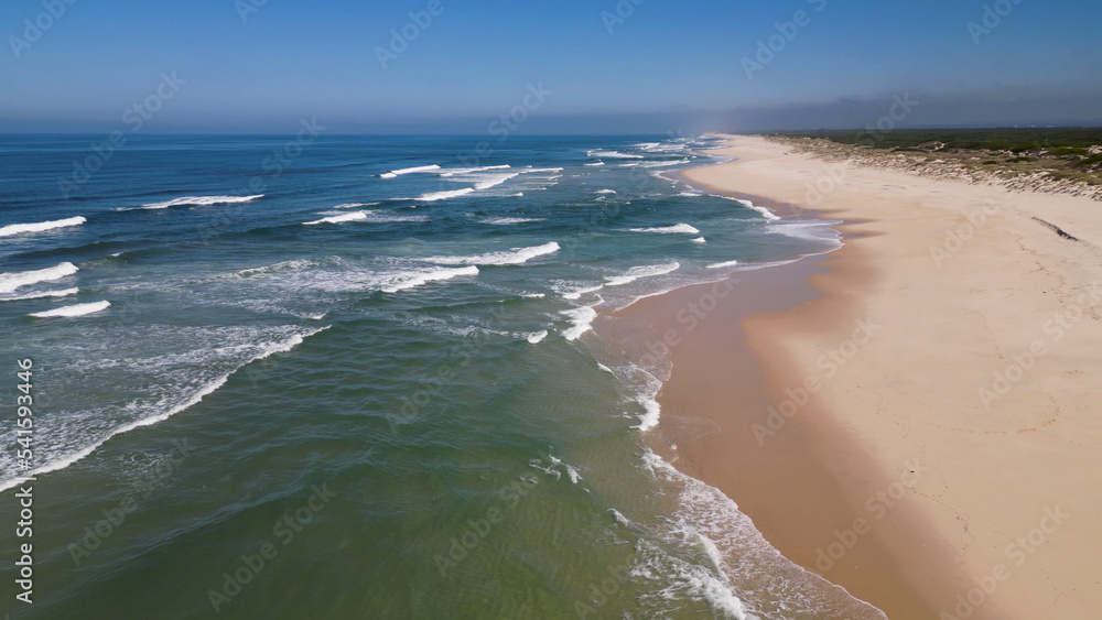 Wall mural Side view of waves crashing on sandy beach