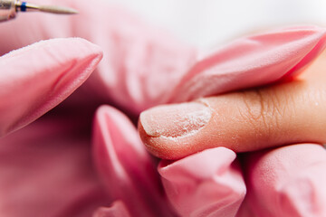 Manicure process. The master polishes the nail using an automated machine. Drill polish remover.
