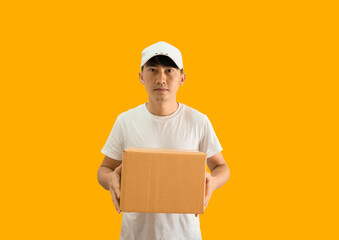 Young Asian delivery man wearing cap and white blank t-shirt holding parcel post box isolated on...