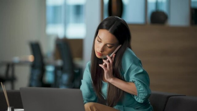 Busy developer answering call at sofa closeup. Manager watching laptop at office