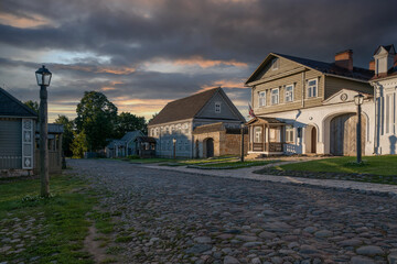 View of historical merchant buildings of estates on the main street of Izborsk Pechorskaya Street on a summer sunny day, Izborsk, Pskov region, Russia