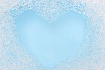 white soap bubbles floating heart shaped blue background love concept