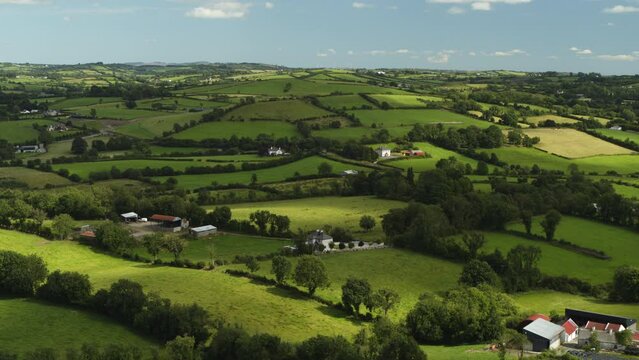 Aerial flyover view of houses in rural rolling landscape / Cavan, Cavan, Ireland