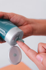 High quality photography. Finger taking skin care products on an isolated white background.