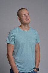 A young cute blonde posing on a white background. Dressed in a T-shirt and jeans. close-up portrait.
