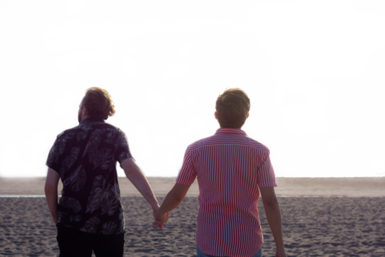 Boyfriends holding hands on the beach, gay couple, pride month