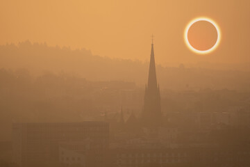 total solar eclipse in early foggy morning on sleeping city