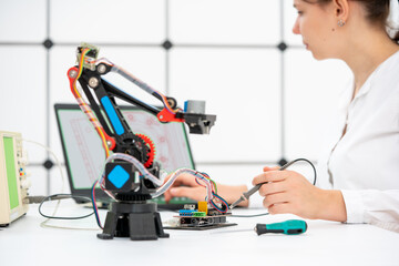 schoolgirl student experimenting with a 3D printed robot model