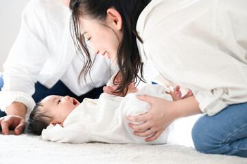 Obraz na płótnie Canvas 赤ちゃんをあやすアジア系のお母さんとお父さん