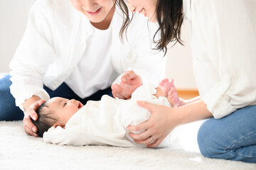 赤ちゃんをあやすアジア系のお母さんとお父さん　顔無しで使いやすい