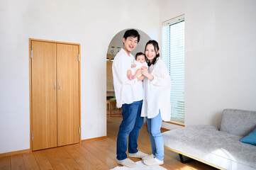 Portrait of Asian family looking at camera in living room Wide angle full body