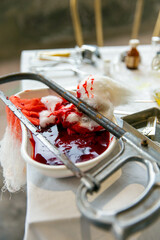 Rusty hacksaw, blood, medical cotton, syringe, medicines on the table. After amputation in the clinic