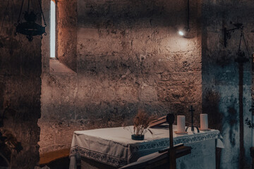 Table with candles in a small ancient medieval stone chapel