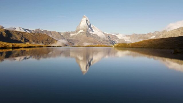 Stellisee Lake. Flying over the lake towards the Matterhorn, Zermatt with mountain reflection during the morning with clear sky