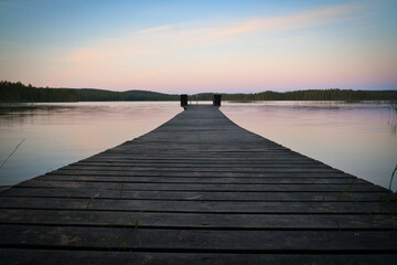 Obraz na płótnie Canvas Wooden jetty reaching into a swedish lake at blue hour. Nature from Scandinavia