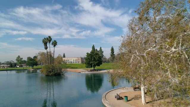 Aerial: Reflection Of Trees In Rippled Rsm Lake, Drone Flying Forward On Sunny Day - Los Angeles, California