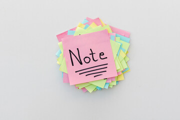 Handwritten word Note on a sticky note with a white isolated background