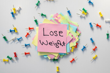 Lose weight hand written text . Motivational reminder on sticky note