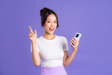 Portrait of a beautiful Asian woman posing on a purple background