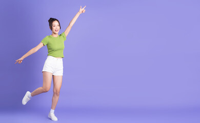 full body image of beautiful asian girl posing on pink background
