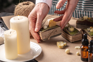 Woman is wrapping a beautiful natural soap. Concept of handmade organic gifts, useful hobby, festive atmosphere