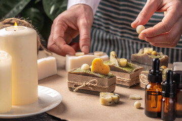 Woman is wrapping and decorating beautiful natural soap. Concept of handmade organic gifts, useful hobby, festive atmosphere