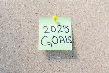 2023 goals hand written on a yellow memo note display on a notice board