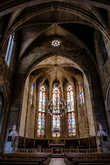 Interior, cross ribbed vault and stained glass of the gothic Saint Etienne collegiate church of Capestang, in the South of France (Herault)