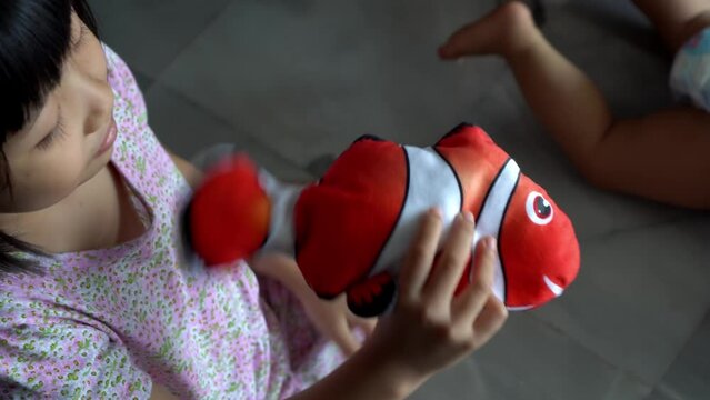 Chinese girl play the nemo fish toy with moving tail.