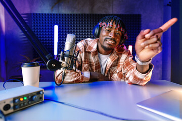 Happy young african man audio blogger broadcasting at studio