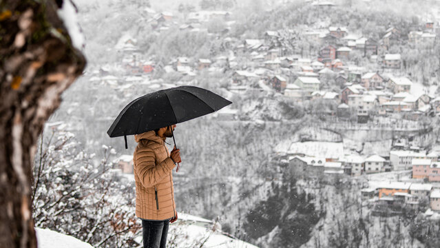 man standing with his umbrella in snowy day.