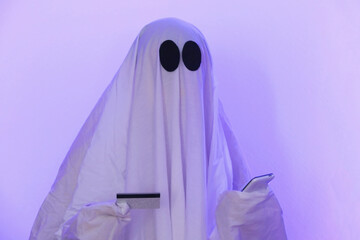ghost Halloween uses mobile phone to surf Internet, to browse online stores, markets. The ghost makes an order from a smartphone for Halloween. Ghost pays online purchase by credit card, bank card.