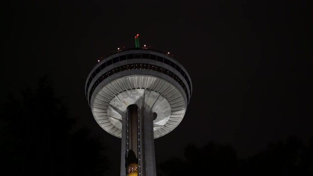 Close up of illuminated Skylon Tower elevator going down, very dark night