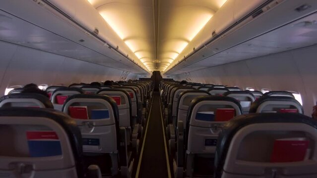 Traveling shot inside an airplane with people sitting down during the flight
