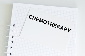 CHEMOTHERAPY text on a white card on the background of a notebook page on the table