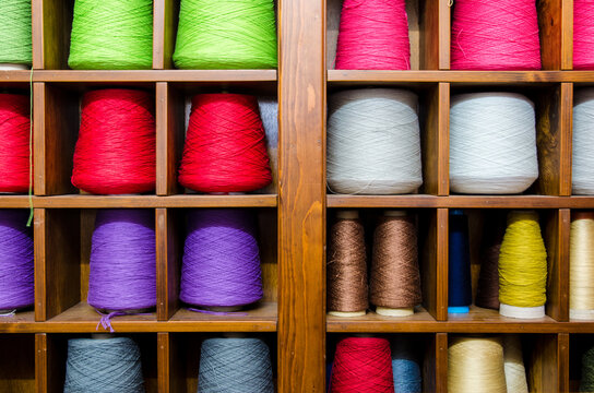 I rocchetti di filo di vari colori sistemati in un mobile all'interno di una industria tessile