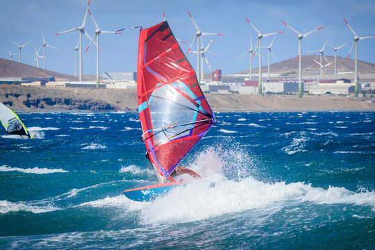 Two people windsurfing with wind turbines in the background, Pozo Izquierdo, Gran Canaria, Canary Islands, Spain