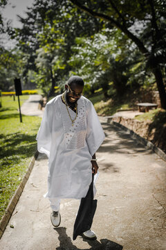 an african man in an agbada taking a walk in the park