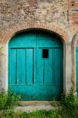Fototapeta na wymiar Il vecchio portone di legno di una casa abbandonata a Toiano di Palaia, borgo abbandonato in provincia di Pisa