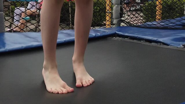 a child jumps on a trampoline in the park