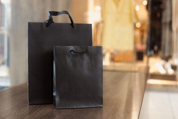 Mock up paper bags with clothes store showcase on background. Black friday sale and shopping...