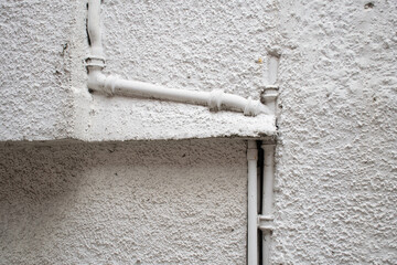 A recessed downpipe in a white facade
