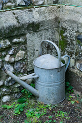 A watercan against a stone wall